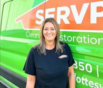 Woman smiling in front of SERVPRO vehicle