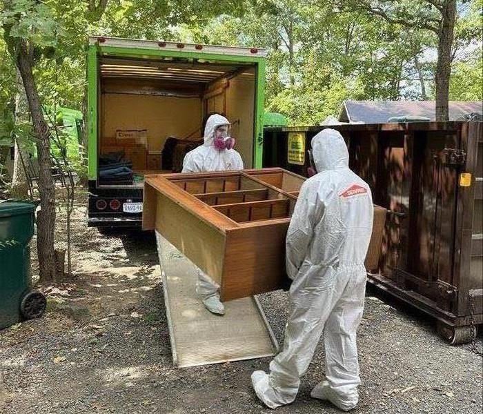 Two SERVPRO members in PPE loading up a SERVPRO vehicle with contents from a local Charlottesville home that caught fire. 