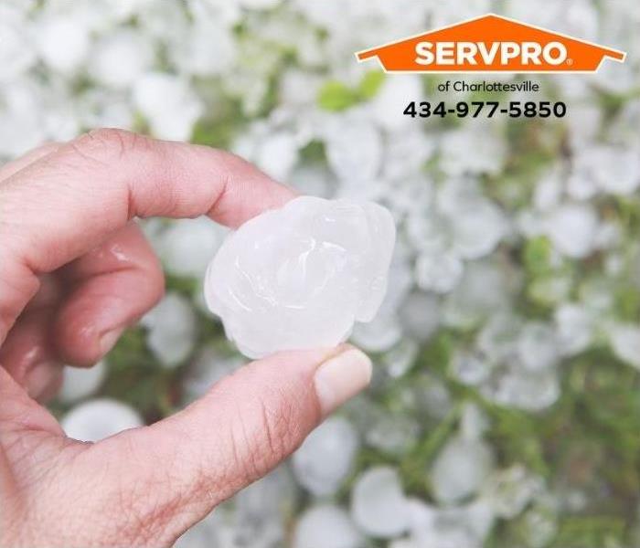 A person holds a golfball-sized hailstone.