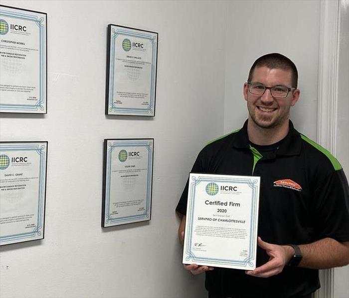 SERVPRO of Charlottesville employee holding our IICRC Firm plaque.